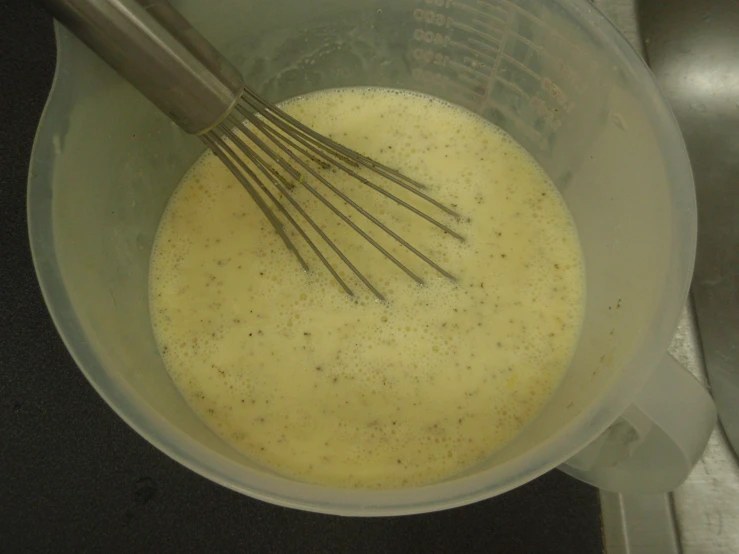 a kitchen tool and its whisk are in a clear pot