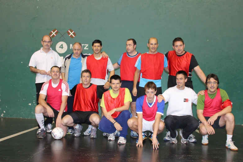 a group of men on the court wearing red and blue shirts