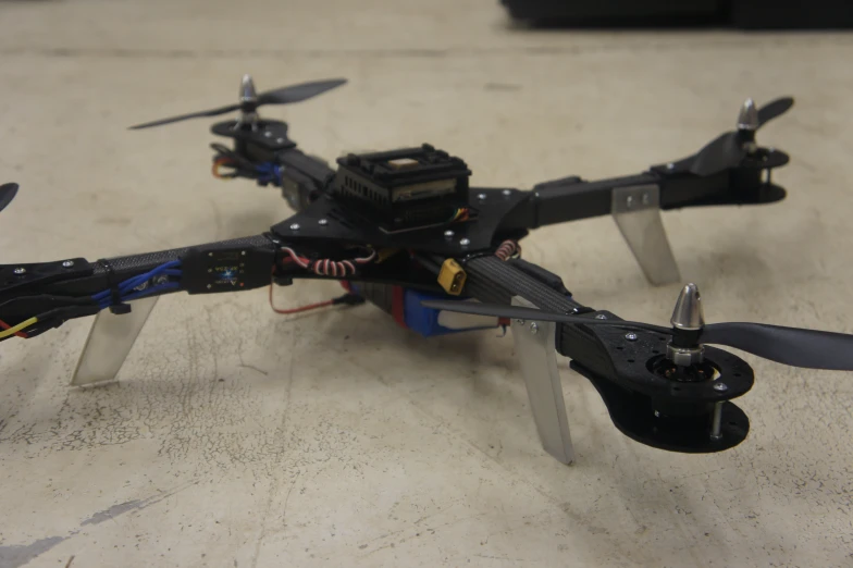 a closeup of an electronics and propeller on a black mini quad propeller flying model