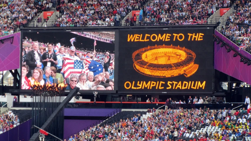 the big screen displaying a welcome to the olympic team