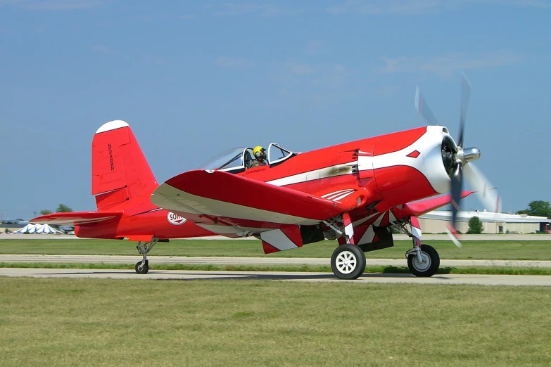 a red and white airplane parked on a runway