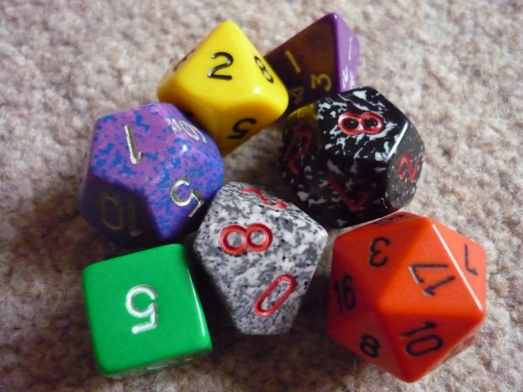 a group of four different colored dice on a gray background