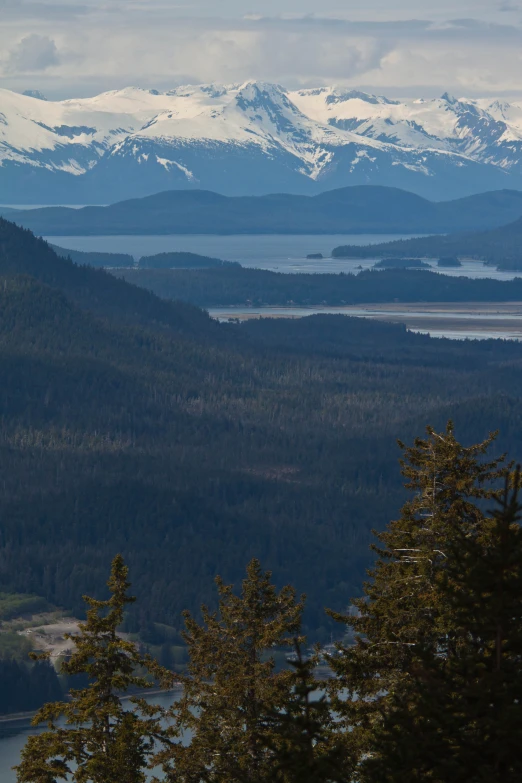 a snow - covered mountain range with a lake in the background