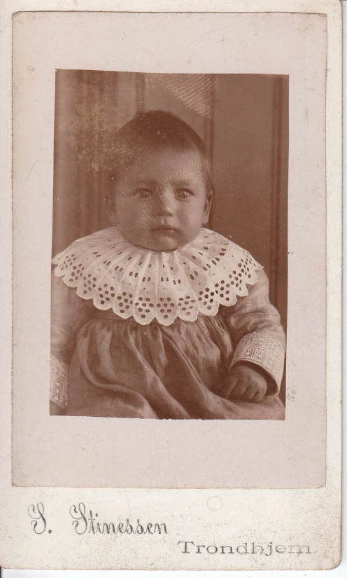 a little child with very large, lacy collared blouse