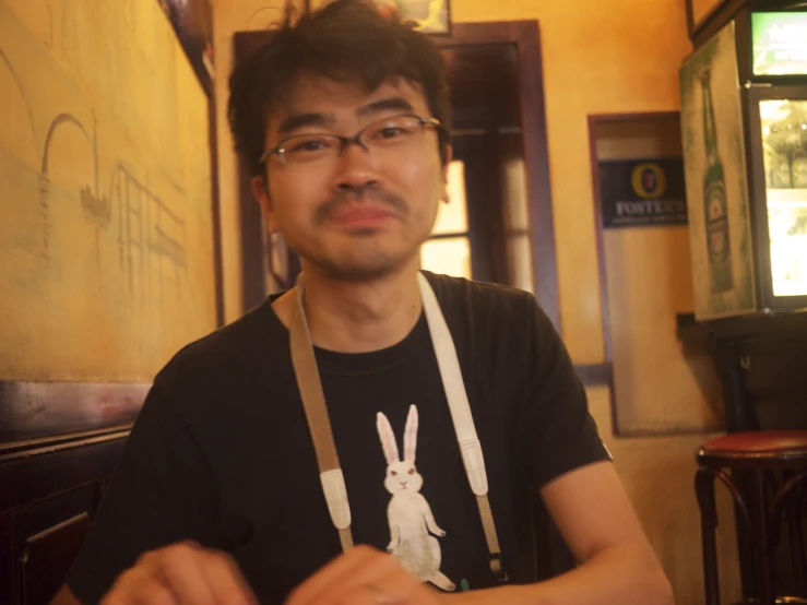 a man wearing a brown apron and holding onto a white stuffed animal