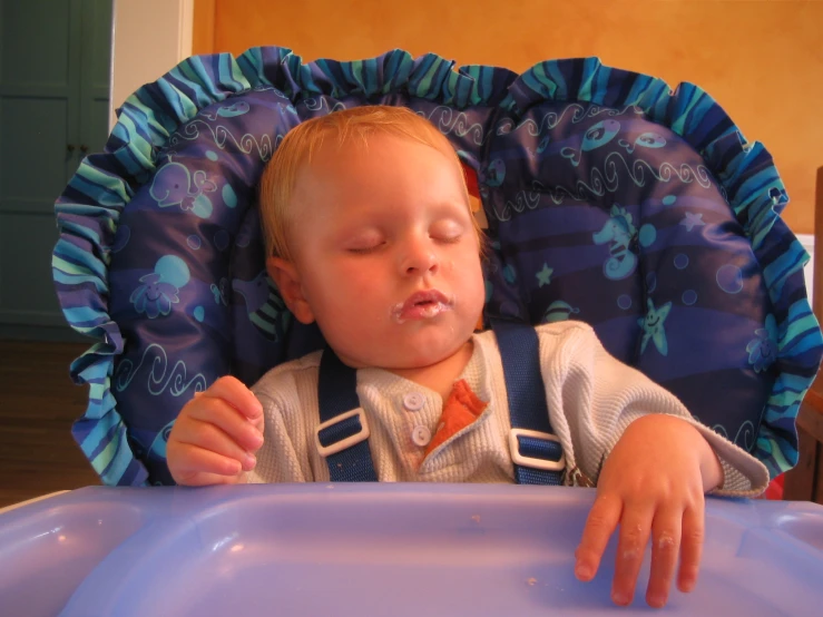 a baby sleeping with a toothbrush in his mouth