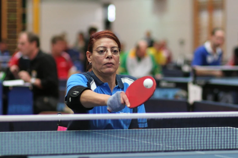 a woman is playing table tennis on the table