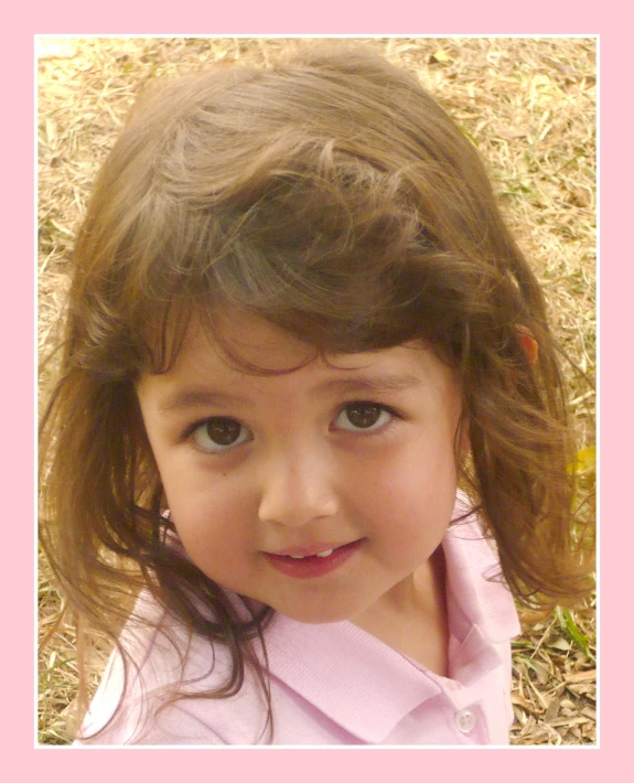 a close up view of a little girl in pink
