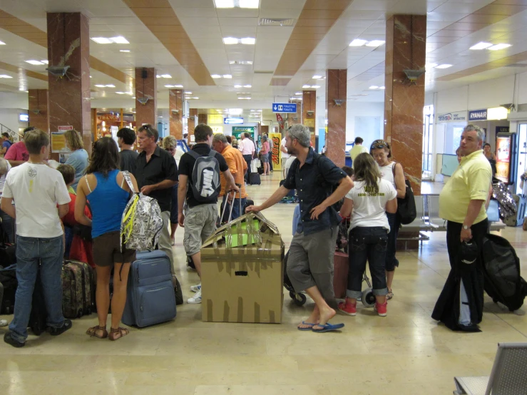 a crowd of people stand around luggage at the airport