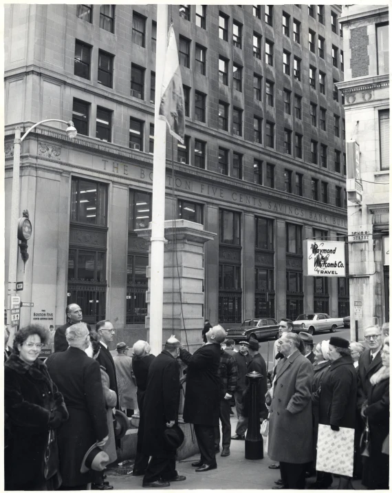 an old pograph of several people standing in front of a building