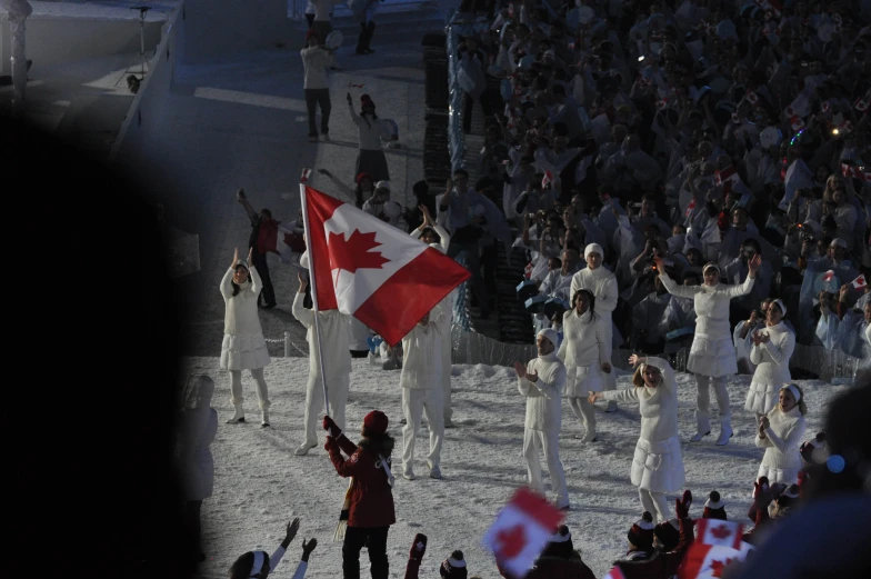 some skiers are holding their canadian flag and waving their hands