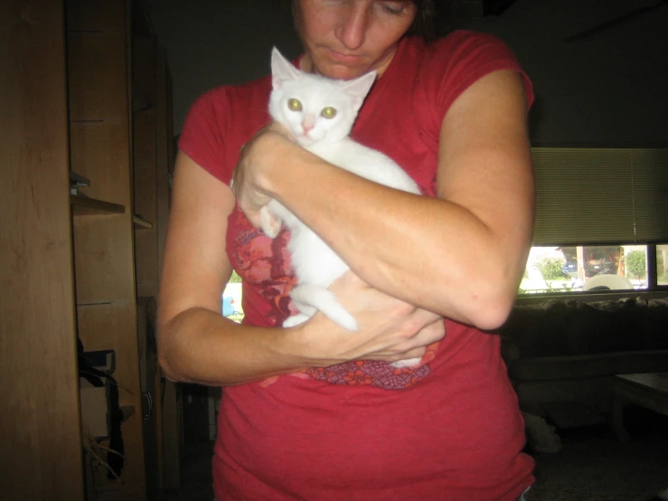 a woman with a white cat in her arms