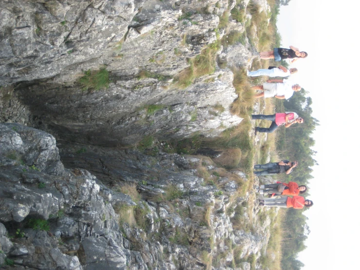 a group of people stand on a rocky area