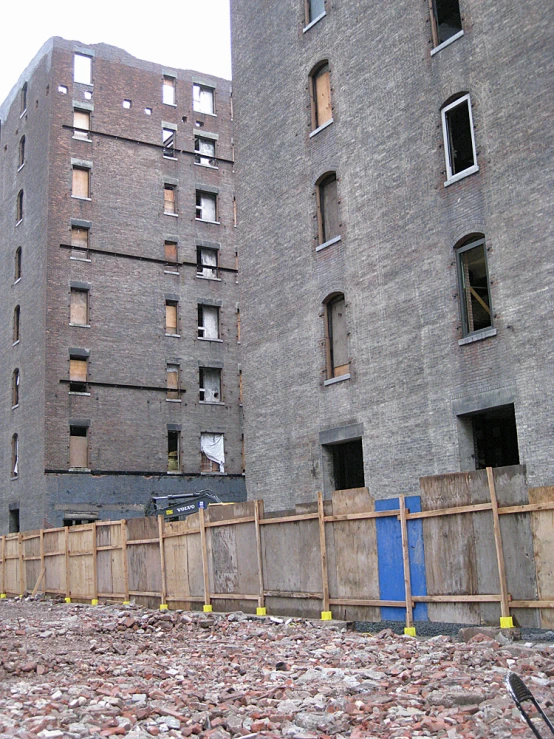 a building with several windows next to a fence and road