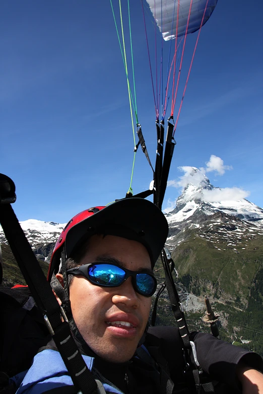 a man riding a parachute flying through the sky