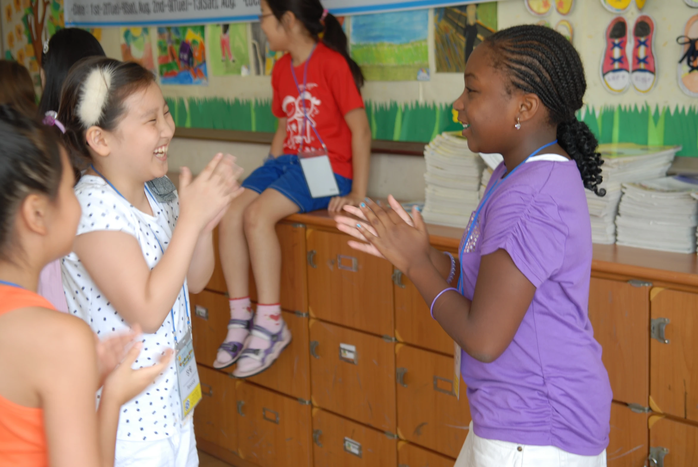 a girl laughs while other girls stand around in the background