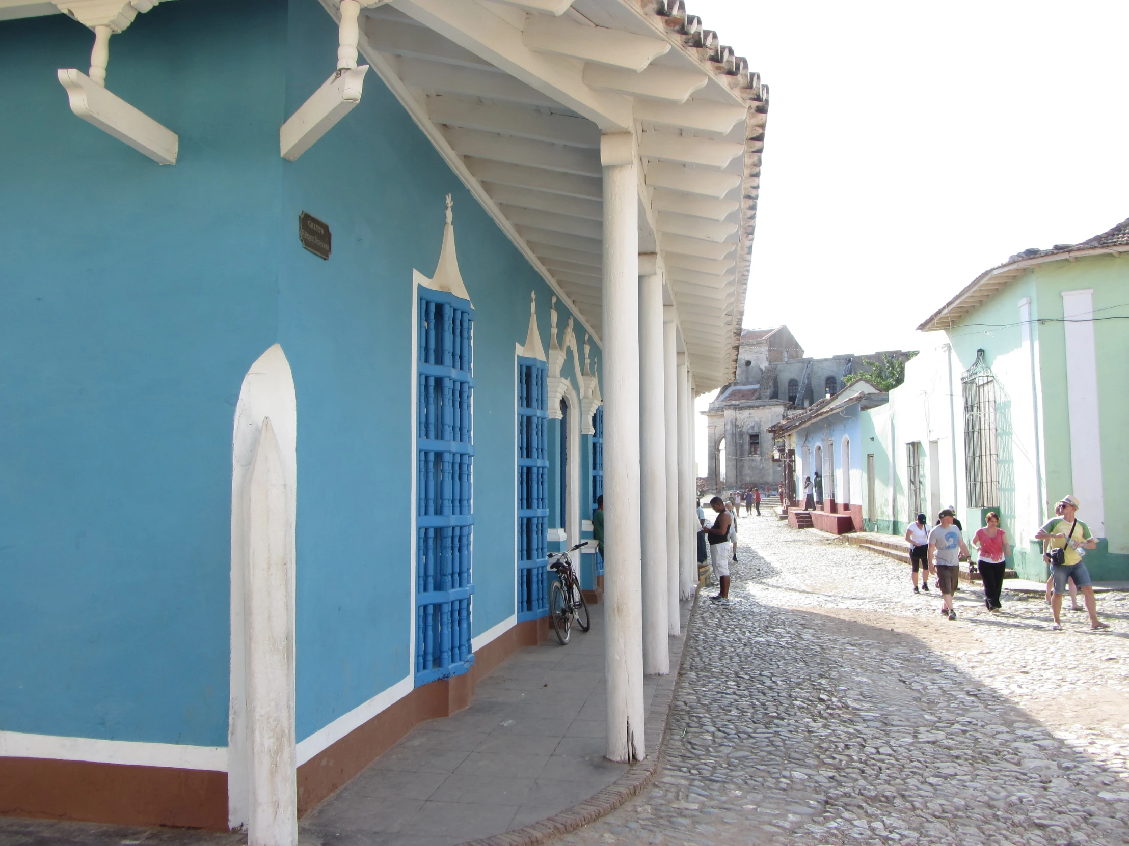 a colorful building with people walking along the sidewalk