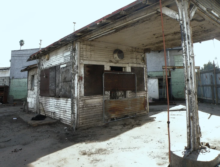 an old wooden building in a dusty lot