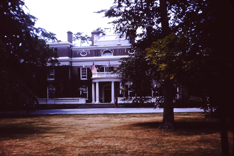 the large building with columns is surrounded by trees