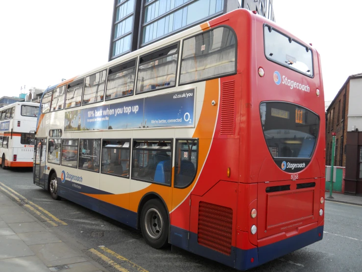 a double decker bus is next to a double decker bus on the street