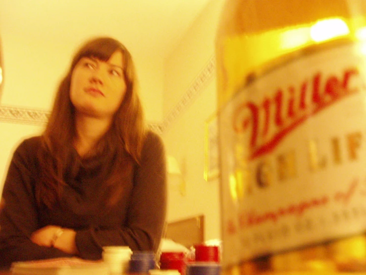 woman sitting on table with beverage bottle in the background