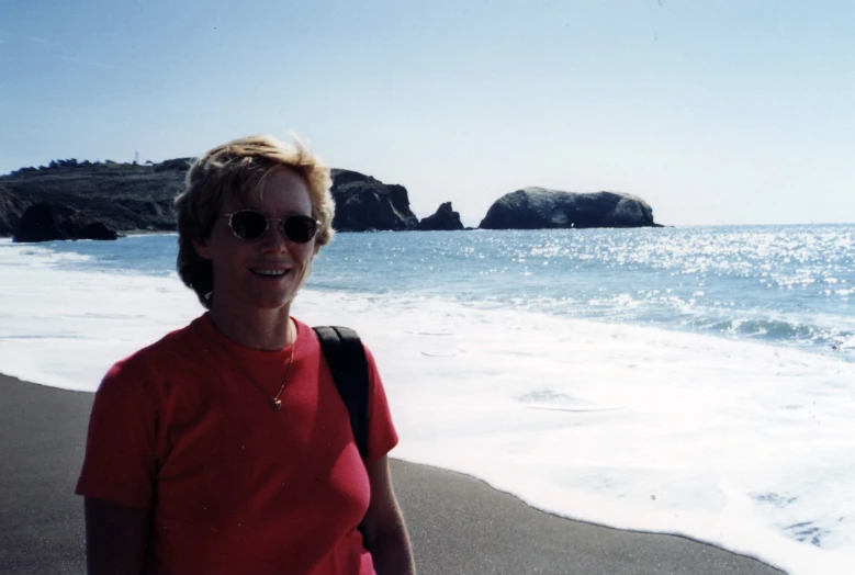 the woman is walking along the beach smiling