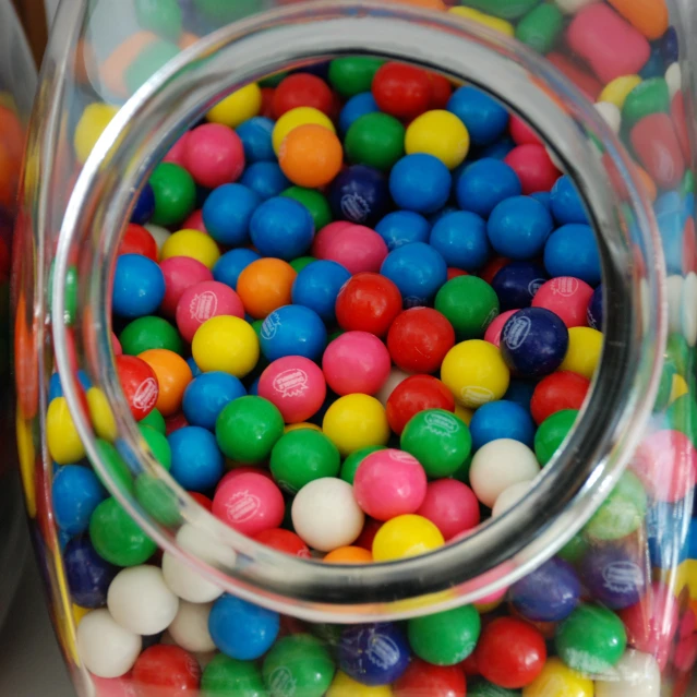 a jar of colorful candy balls inside of it