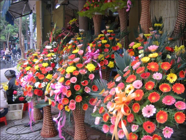 a lot of different colored flowers lined up on the side of the street