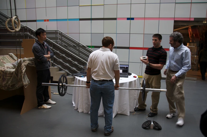 three men are in front of a display with items