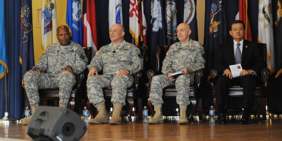 four men in military uniforms sit near each other