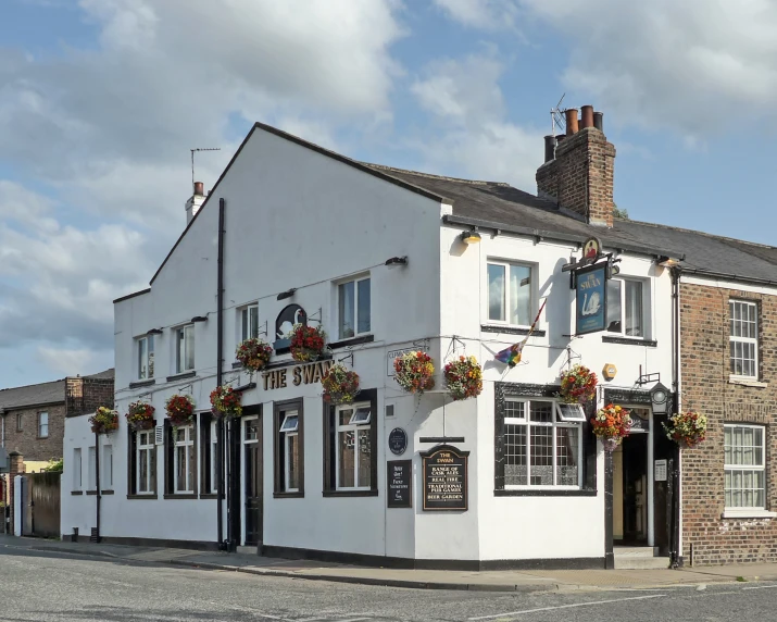 there are several flower boxes hanging outside this pub