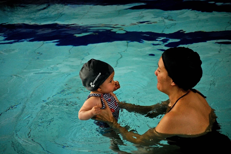 a father and son playing in a swimming pool