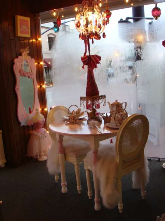 table, chair, and other decorations sit in front of a window