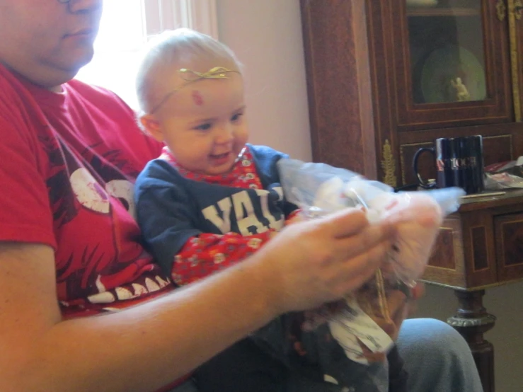 a child with a golden halo is sitting on the lap of an adult