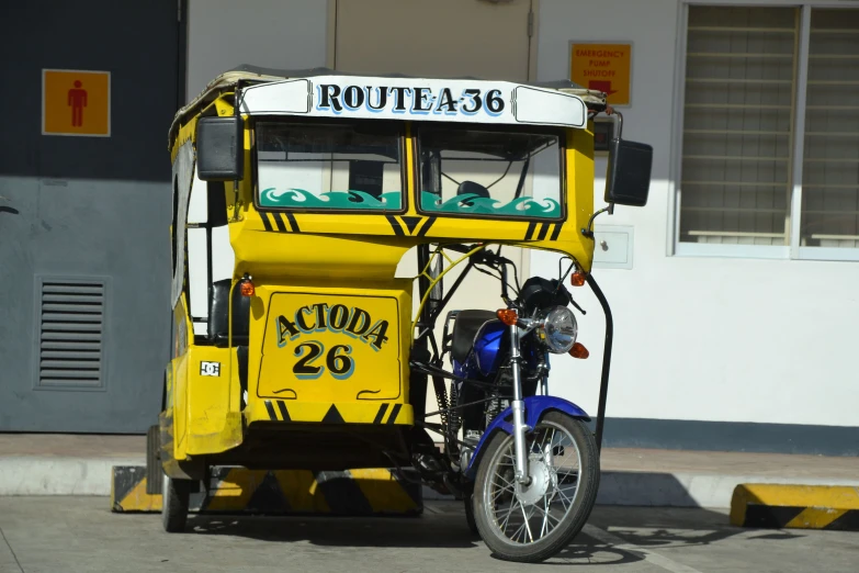 a blue motorcycle that is standing next to a yellow bus
