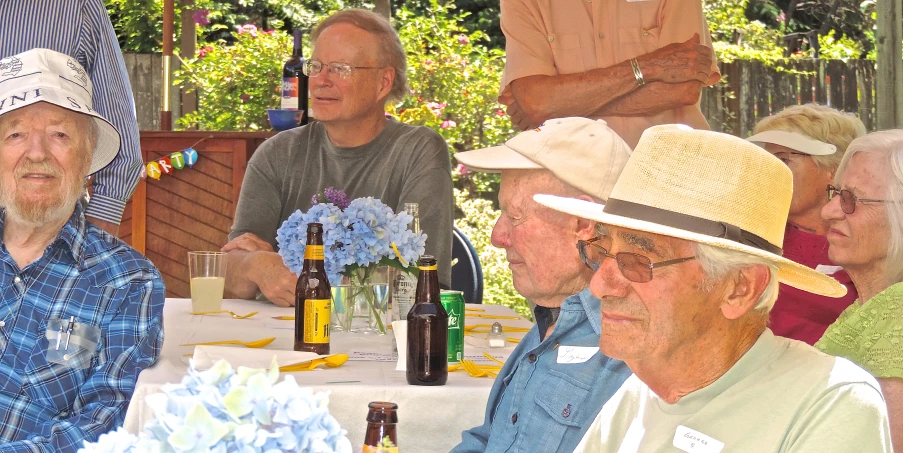 a group of men sitting at a table with bottles of wine