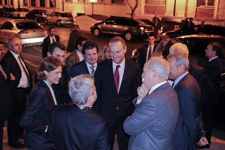 a group of men wearing suits talking and having conversation