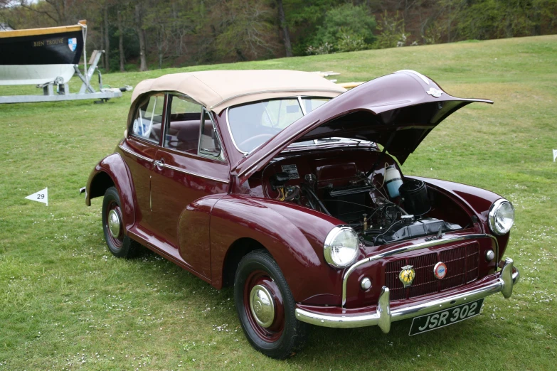 an old time maroon car with a beige roof