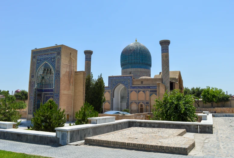 an old building is surrounded by green and blue mosaic work