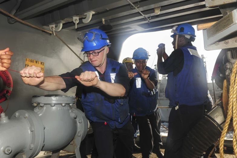 some people in hard hats and blue overalls