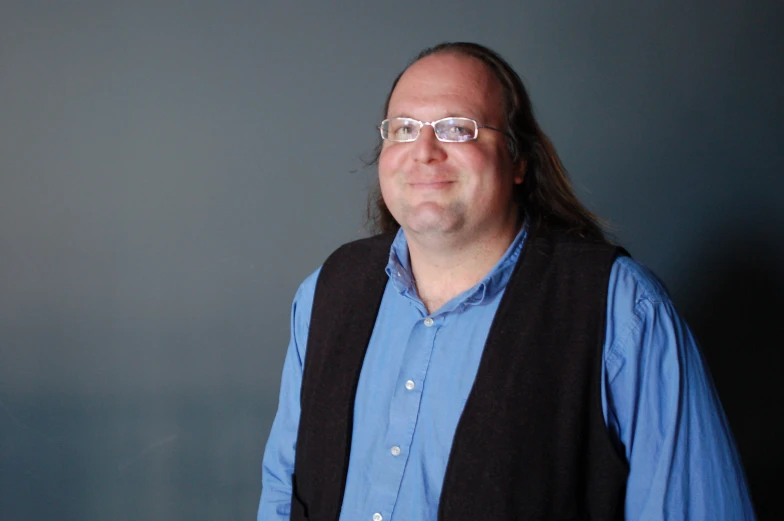 a man with glasses and a vest is standing up