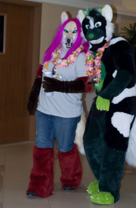 two people in animal costumes on display with a large black dog