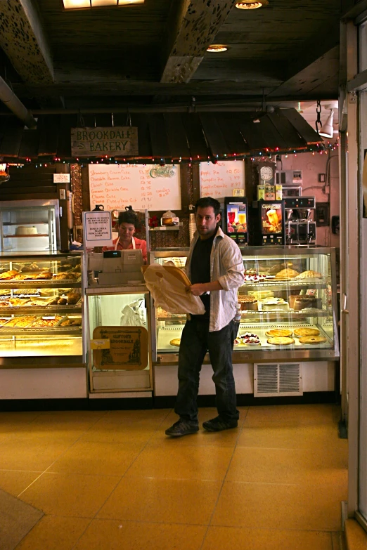 a man standing at the counter at a bakery