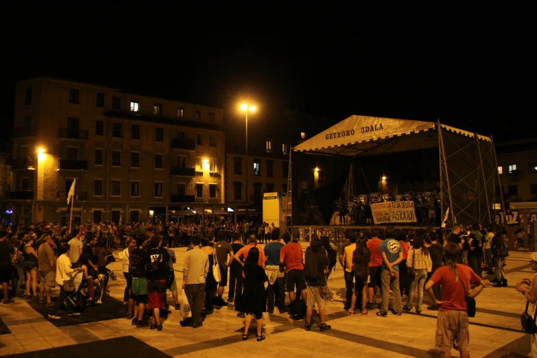 many people gathered in a plaza on a crowded evening