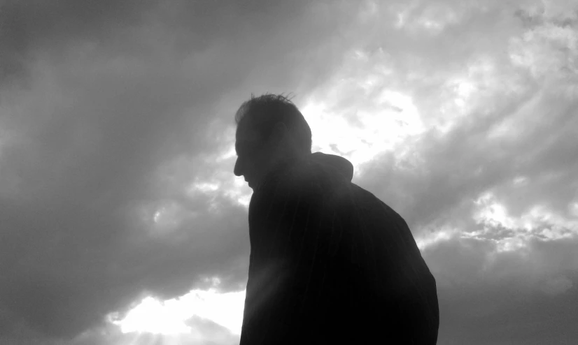 silhouetted person on dark clouds in background