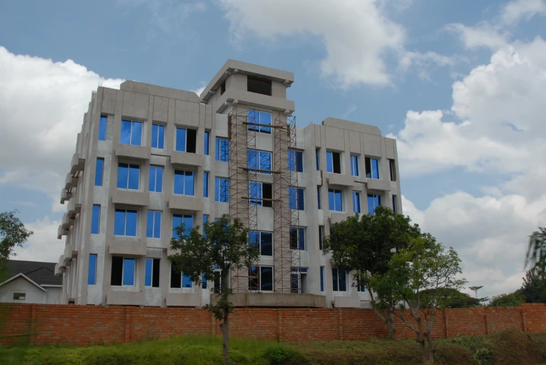 a building that is built out of concrete with blue windows