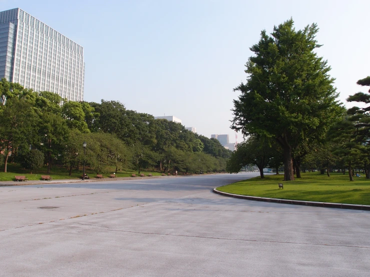 an empty street surrounded by grass and trees