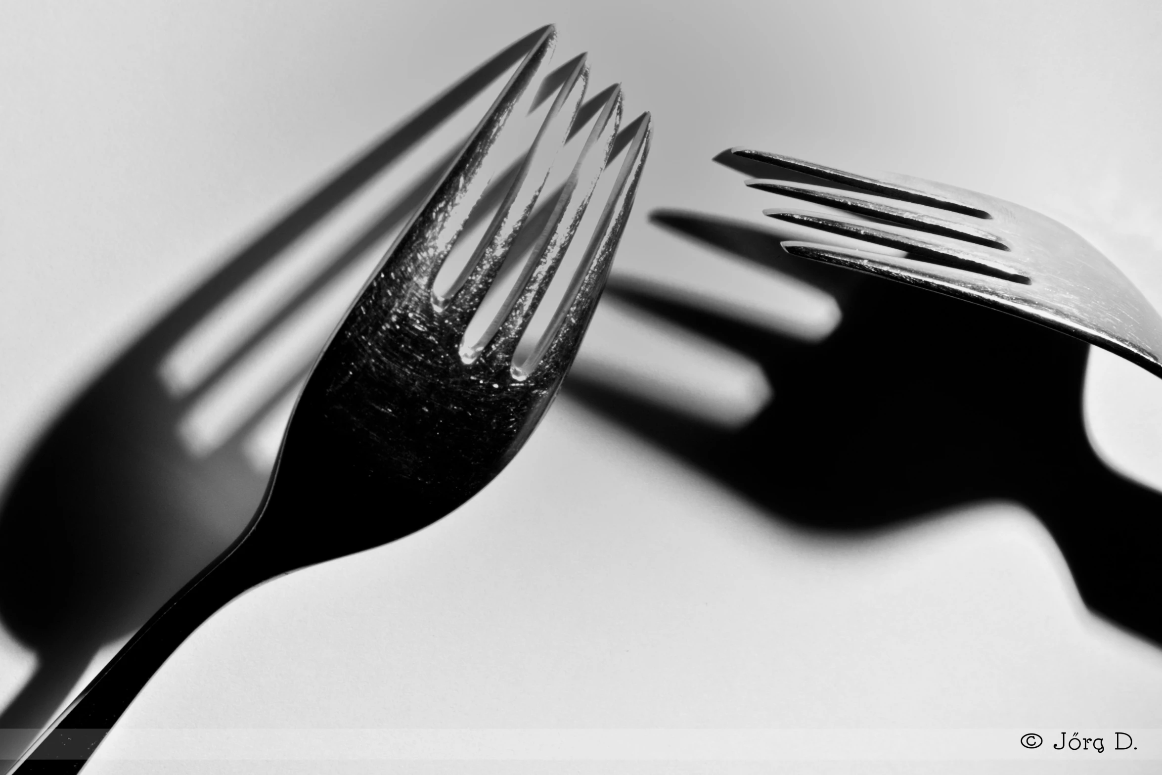 black and white pograph of two forks in the shape of a heart