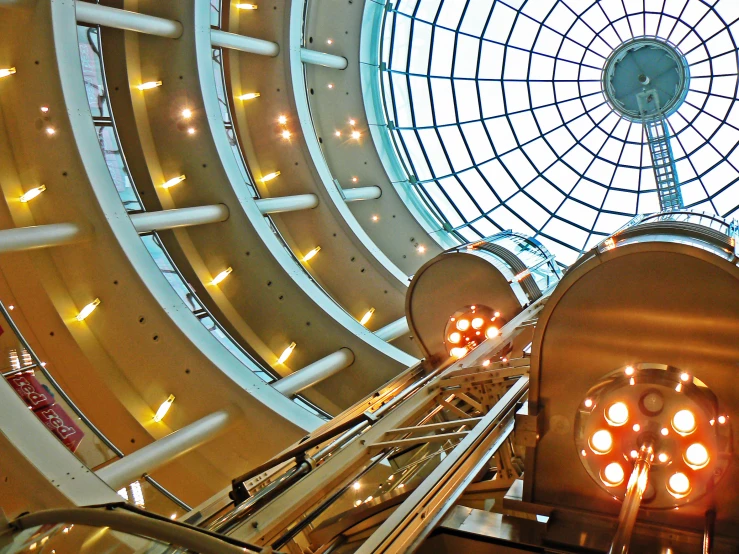 a round glass ceiling and escalators inside a building