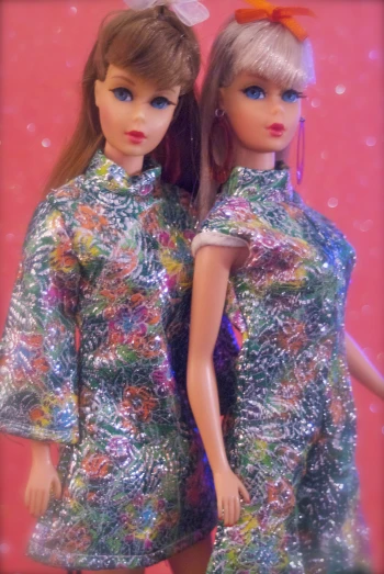 two barbie dolls wearing silver sequins in a picture